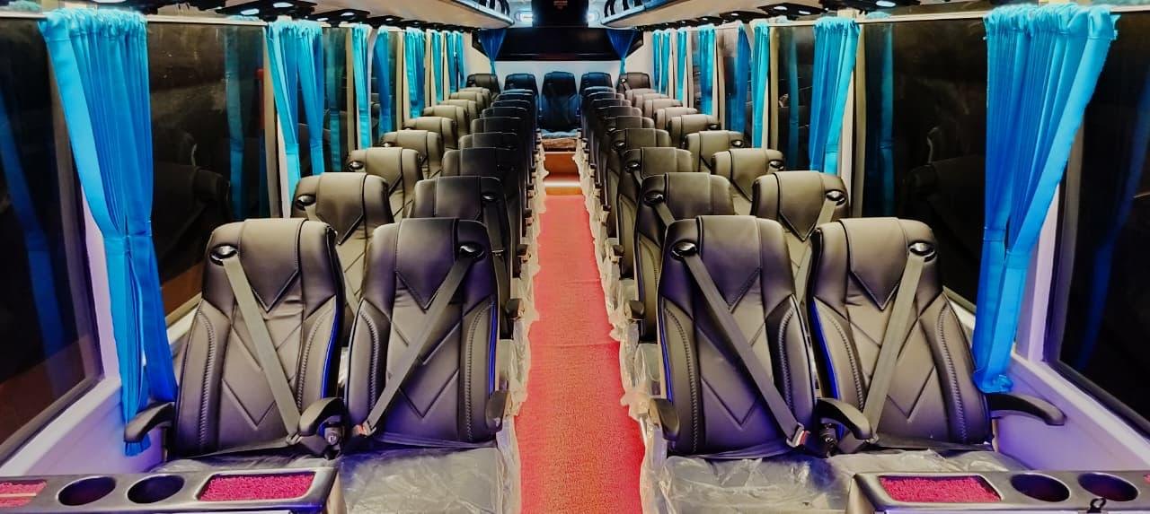 Coach interior with rows of black leather push-back seats along a red aisle