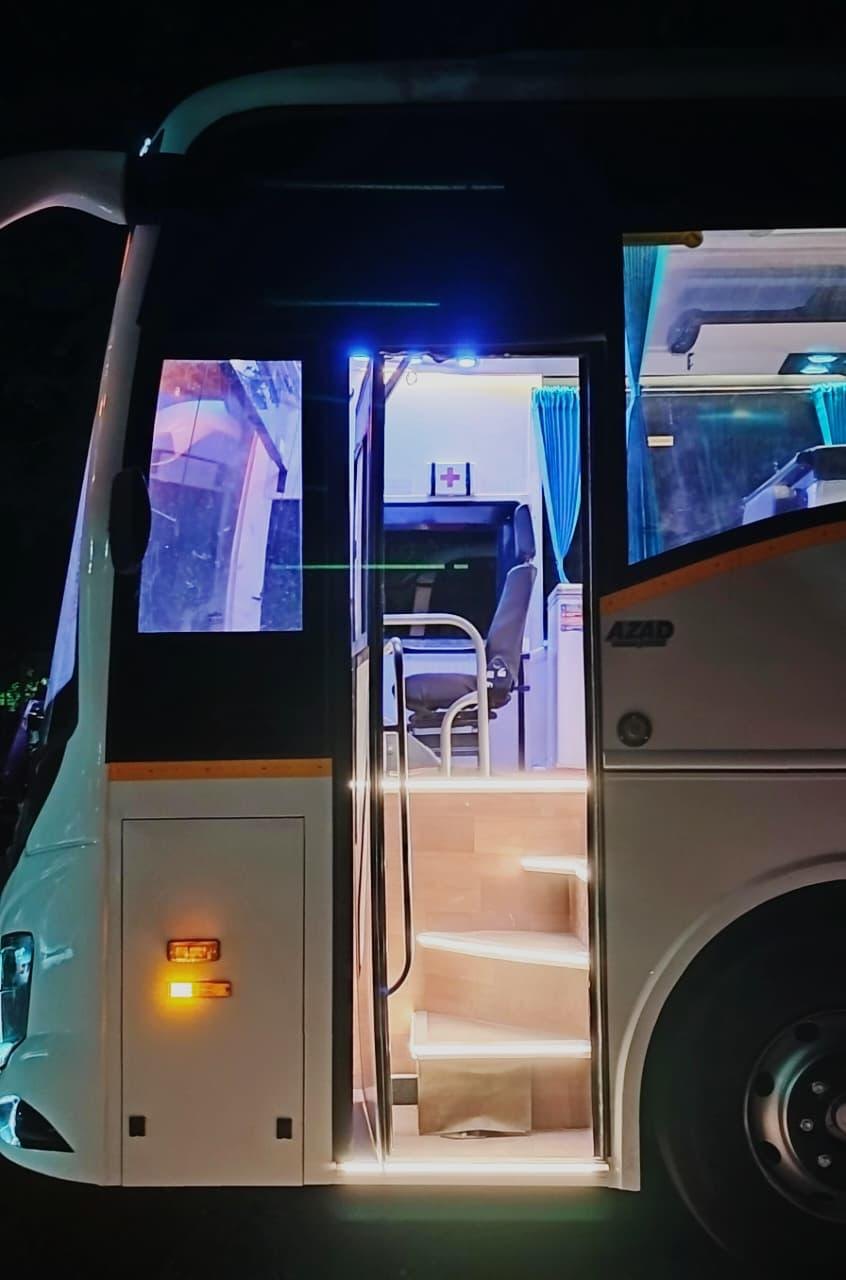 Lit entrance steps of a luxury coach at night